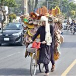 A street vendor wanders the roads, selling handicraft items from his bicycle to earn livelihood in the federal capital