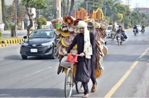A street vendor wanders the roads, selling handicraft items from his bicycle to earn livelihood in the federal capital