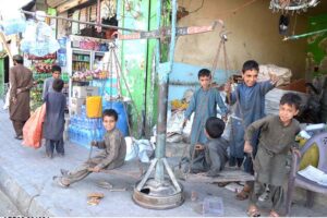 Children after selling their collected scrap, joy in their surroundings, turning a weight scale into a source of fun at the scrap yard