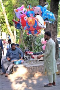 A street hawker displays colorful balloons to attract the customers at Aabpara.