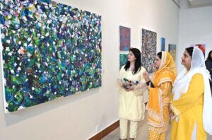 An art enthusiast keenly observing the exhibits during the inauguration of "PASSAGES OF LIGHT," an exhibition featuring paintings by Sri Lankan artists Mueen Saheed and Bilaal Raji Saheed at the Pakistan National Council of the Arts (PNCA).