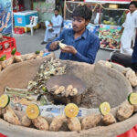 A vendor displaying roasted sweet potatoes (Shakarkandi) to attract the customers on roadside in the City