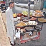 A hawker roasts peanuts on the roadside, the tempting aroma attracting passersby in the federal capital