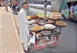 A hawker roasts peanuts on the roadside, the tempting aroma attracting passersby in the federal capital