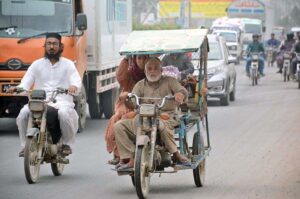 An aged man driving a motorcycle-cart for livelihood in the city.