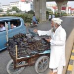 A vendor displaying a variety of slippers on his handcart for sale at the roadside, inviting customers with reasonable prices in the federal capital