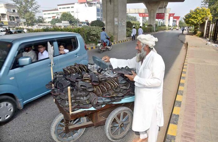 A vendor displaying a variety of slippers on his handcart for sale at the roadside, inviting customers with reasonable prices in the federal capital