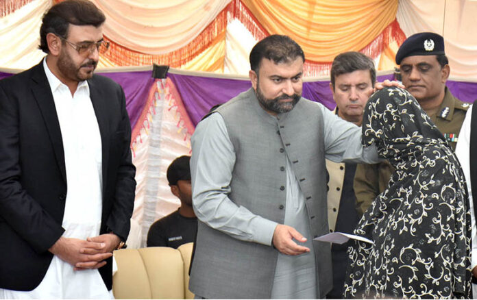 Chief Minister Balochistan Sarfraz Bugti is giving cheques to the family members of laborers killed in terrorist attack in Balochistan at Shuja Abad
