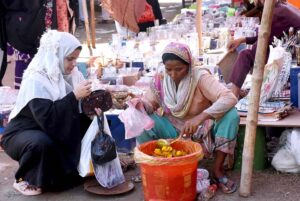 A woman buying pickle from a vendor.