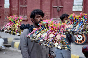 Gypsy vendors selling handmade toys for children while shuttling on the road to earn livelihood in the city.