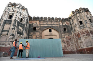 Laborers cordon off the restoration area with stainless steel sheets before beginning work on the backside gate of the Historical Lahore Fort.