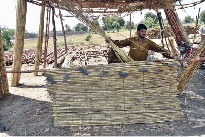 A man crafts traditional bamboo chicks at his workplace in the city