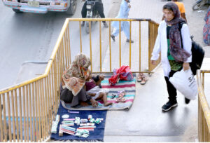 A Woman along with her baby girl sells combs and other items at the pedestrian bridge to earn livelihood in the Provincial Capital.