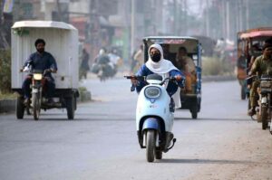 A woman rides her scooty down Naranwala Road towards her destination.