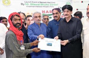 MNA Khursheed Ahmed Junejo distributing the Benazir Hari Card issued by the Sindh Government among Hari during a function at Begum Nusrat Bhutto Hall Jinnah Bagh.