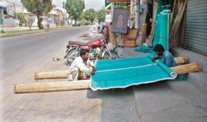Workers busy in making traditional curtains at roadside setup.