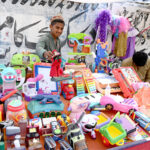 Vendor displaying plastic toys to attract the customer at Makki Shah Road