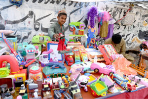 Vendor displaying plastic toys to attract the customer at Makki Shah Road