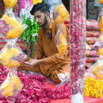 A vendor arranging and displaying flower garlands to attract the customers at Banni Chowk