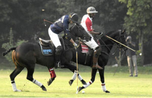 Players fiercely struggle to gain control of the ball during the polo match between Newage Cables and Olympia Polo Team in the Polo in Pink Cup 2024 at Lahore Polo Club