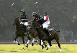 Players fiercely struggle to gain control of the ball during the polo match between Newage Cables and Olympia Polo Team in the Polo in Pink Cup 2024 at Lahore Polo Club