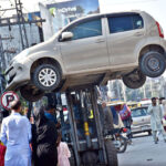A traffic warden moving an illegally parked car with the help of lifter