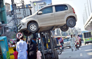 A traffic warden moving an illegally parked car with the help of lifter