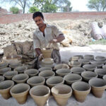 Craftsmen busy in preparing clay made pots at his workplace