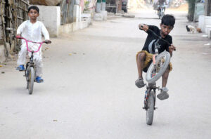A boy pumps water with a hand pump to fill his pots for domestic use as the city faces a water shortage