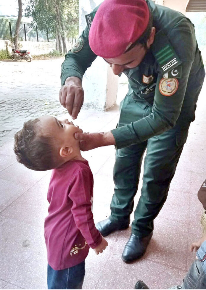 A worker of Rescue 1122 is administering polio drops to children in different areas of the provincial capital for polio prevention campaign in Pakistan