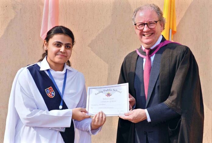Mr. David Dowdles, Principal of Sadiq Public School,giving certificates and trophies to students who excelled in the annual Urdu debate program at the school in the city