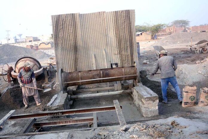 Labourer busy in preparing cement sewege pipe at their workplace