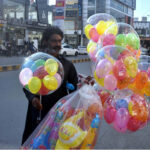A vendor selling colorful balloons to attract customers at roadside