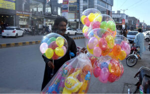 A vendor selling colorful balloons to attract customers at roadside