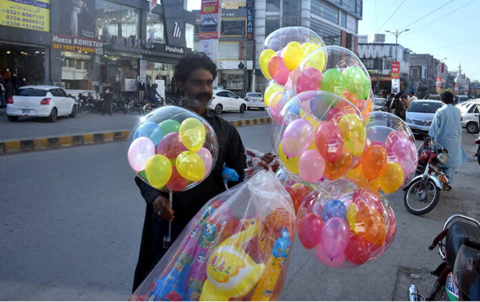 A vendor selling colorful balloons to attract customers at roadside