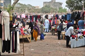 People are selecting and purchasing second-hand warm clothes from Landa Bazaar at Zia Masjid Stop along Express Highway