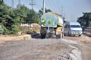 Labourers busy in construction work of bridge at service road along Karnal Sher Khan Shaheed Road during development work in the city.