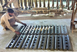 A laborer places concrete pillars under the sun for drying purpose.