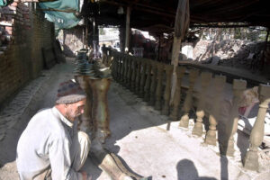 A laborer places concrete pillars under the sun for drying purpose.