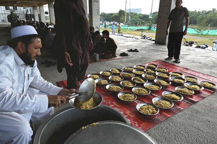 Volunteers distribute free food among poor people and daily wage laborers at Ghouri town Vip block