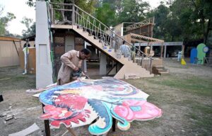 Workers are busy in installation a model of the provincial major cities for the upcoming Folk Festival "Lok Mela 2024" at Lok Versa in the Federal Capital.