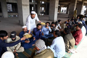 Volunteers distribute free food among poor people and daily wage laborers at Ghouri town Vip block