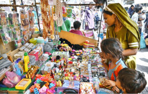 A woman selecting and purchasing different items displayed by vendor at Tower Market