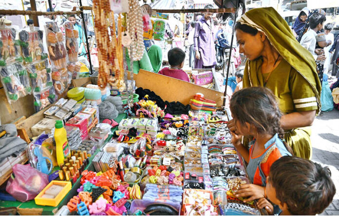 A woman selecting and purchasing different items displayed by vendor at Tower Market