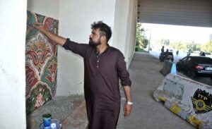 A painter busy making painting under the bridge at Zero Point in Federal Capital.