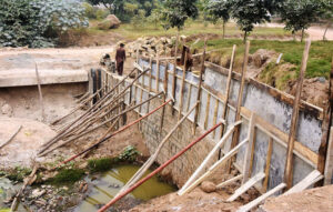 Laborers busy in construction work of the side wall to control sewage overflow and reinforce construction along the bridge near IJP road in the federal capital, ensuring safer development for the community.
