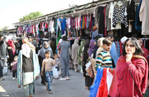 People busy selecting and purchasing second hand clothes from vendor at weekly Bazaar in the Federal Capital.