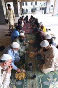 Volunteers distribute free food among poor people and daily wage laborers at Ghouri town Vip block
