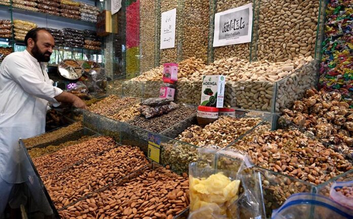 A shopkeeper arranging and displaying dry fruit to attract the customers at Aabpara