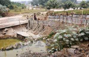 Laborers busy in construction work of the side wall to control sewage overflow and reinforce construction along the bridge near IJP road in the federal capital, ensuring safer development for the community.